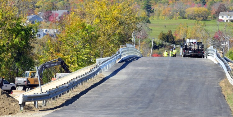 Workers complete the bridge replacement work Friday before re-opening the Winthrop Street bridge over Interstate 95 in Hallowell.