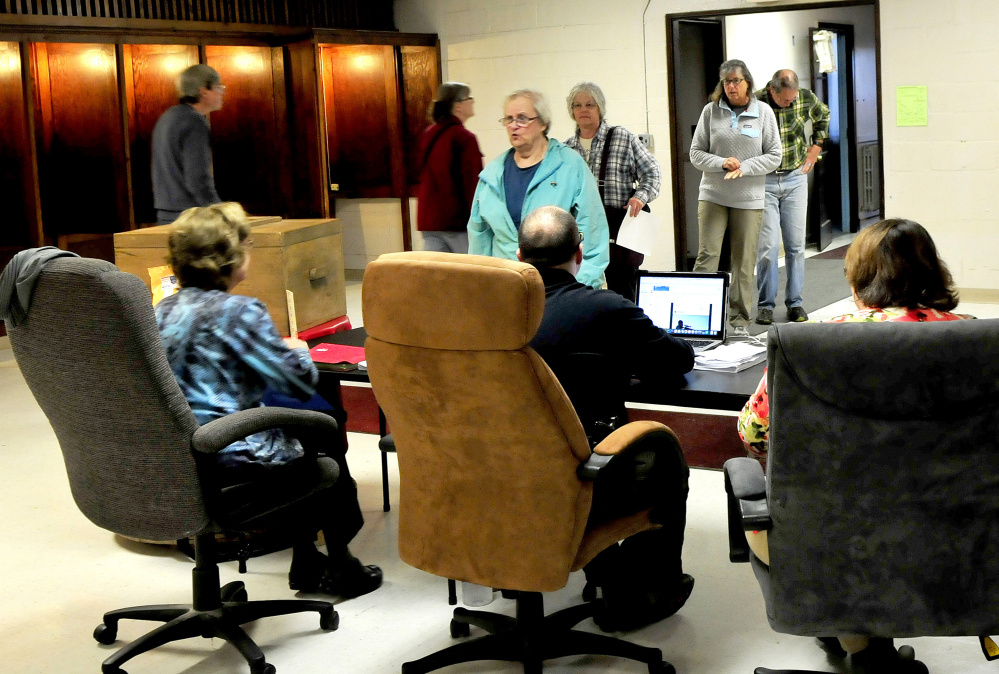 Farmington residents get ballots for the Regional School Unit 9 budget referendum Tuesday from clerks as others at the Community Center in Farmington. It was the fourth vote on the budget.