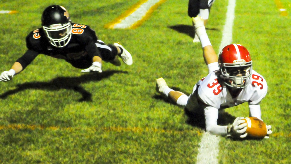 Cony's Elijah Dutil, right, catches a pass just short of the goal line as Gardiner's Matt Boynton plays defense during a game Friday at Hoch Field in Gardiner.