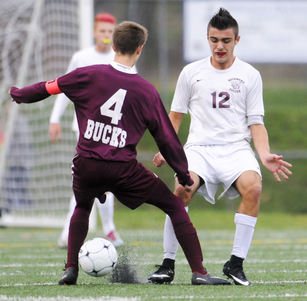 Rubber chips from the turf pop up as Buckfield's Tobias Worthley, left, and Richmond's Zach Small battle for a ball in the Class D South championship game Thursday at McMann Field in Bath.