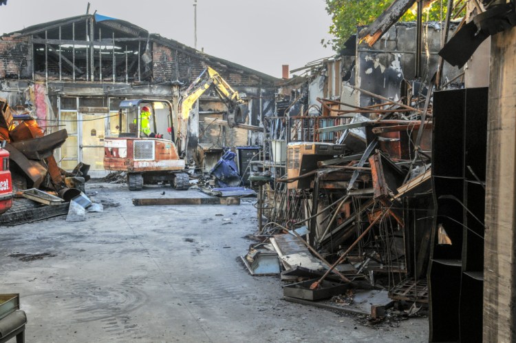 Ken Muse, of Muse Micro-Excavating, sorts metal debris for recycling on Friday inside the burned out U.S. post office in Winthrop. Subcontractors were working at the site clearing the way for a new building.