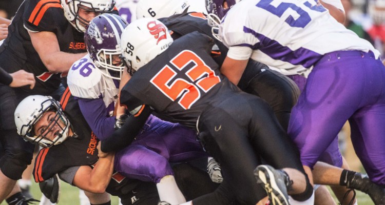 Skowhegan defender Jake {rice (56) tackles Marshwood ball carrier Kyle Gladden during the season opener Sept. 1 in Skowhegan.