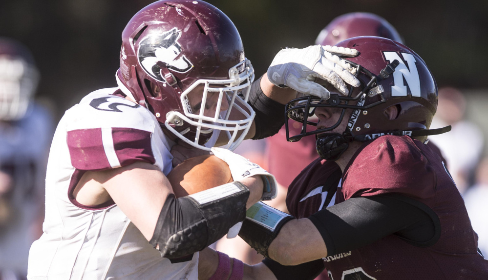 Maine Central Institute running back Adam Bertrand, left, stiff-arms Nokomis defender Andrew Haining during a Class C North quarterfinal game earlier this season in Newport.