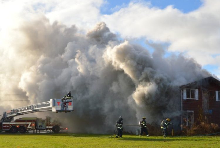 Heavy wind-driven smoke hampers visibility as local fire departments battle a house fire Friday morning at 167 Morrison Hill Road in Farmington.