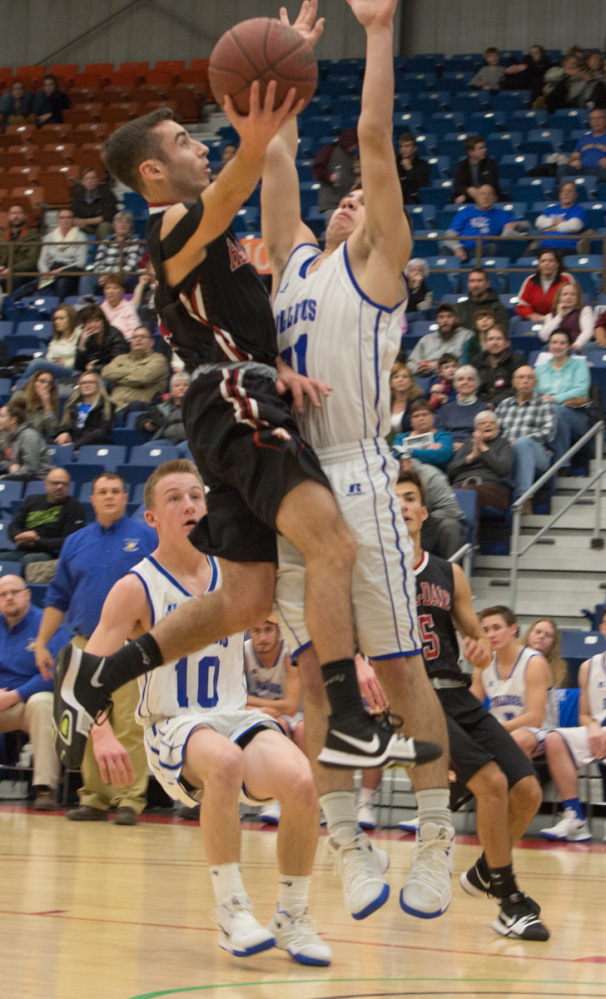 Hall-Dale's Tyler Nadeau, left, goes for a layup while being defended by Madison's Justyn Stinson, right, at the Maine Gold Rush Invitational Tournament on Tuesday at the Augusta Civic Center.