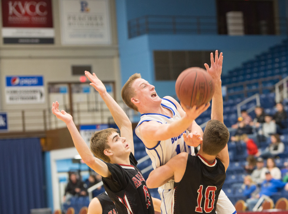 Madison's Evan Bess, center, takes a shot between Hall-Dale's Ashtyn Abbott, left, and  Alec Byron (10) at the Maine Gold Rush Invitational Tournament on Tuesday at the Augusta Civic Center.