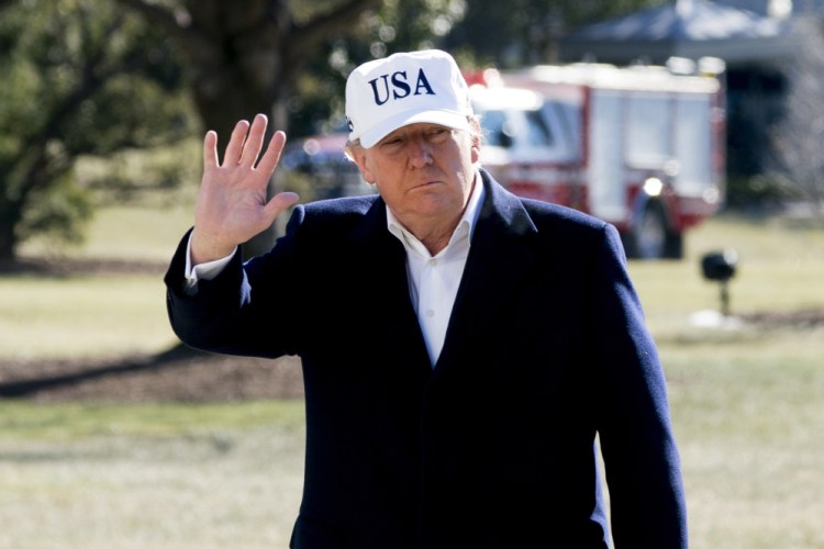 President Trump waves to members of the media as he walks across the South Lawn as he arrives at the White House in Washington on Sunday after traveling from Camp David, Md.