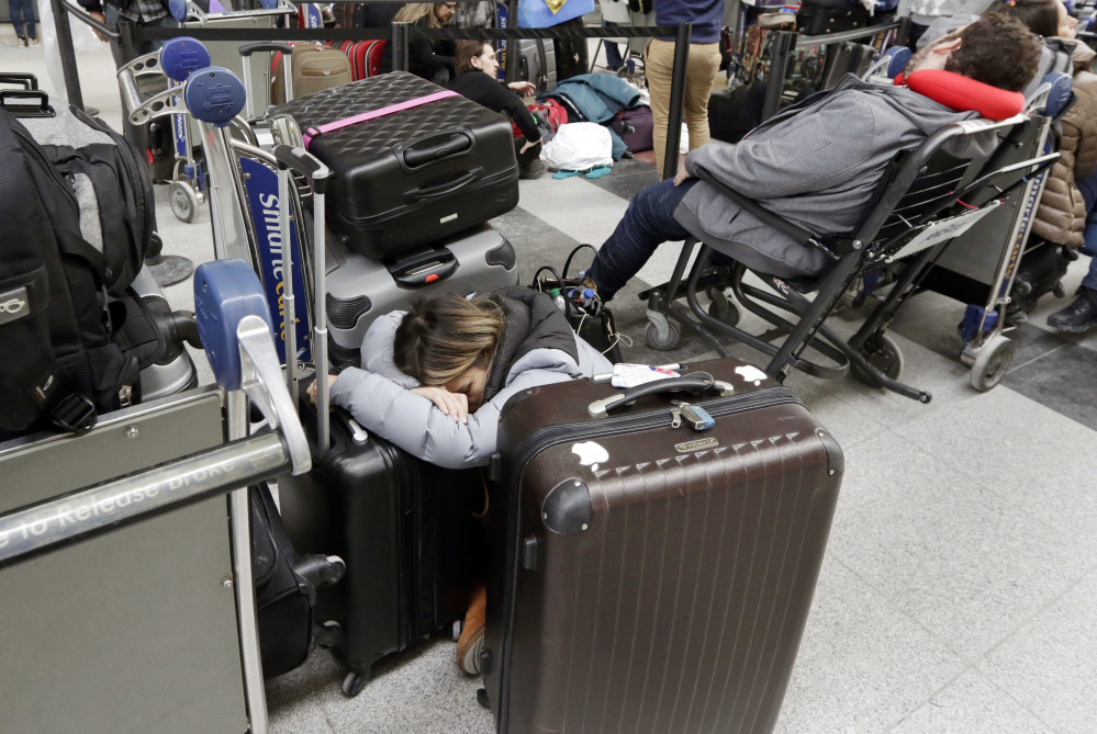 Avianca passengers rest while waiting for their flight at New York's John F. Kennedy Airport Terminal 4 on Monday. The Port Authority of New York and New Jersey said Monday it will investigate the water pipe break that added to the weather-related delays at Kennedy Airport and will "hold all responsible parties accountable."