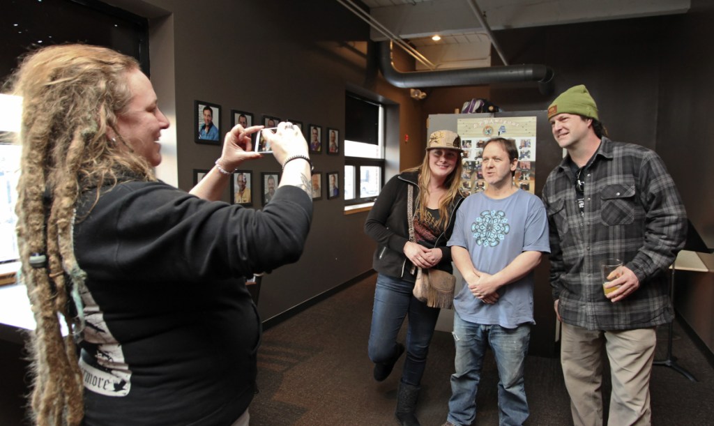 Amy Walker, left, of Steep Falls photographs Jo Lee of Oxford and Tom Obear of Sumner with Phish drummer Jon Fishman, in middle, as Fishman helps gather signatures for a ranked-choice voting campaign at Bayside Bowl on Sunday.