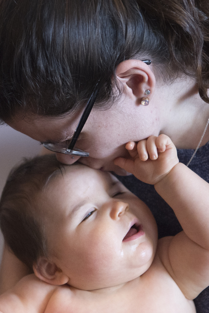 Kayla Clifton kisses with her baby Lilly at the Mid-Maine Homeless Shelter on Wednesday. Karen Normandin, dean of students at Kennebec Valley Community College, is working with Clifton to pay off a back bill and get financial aid so she can return to her studies.