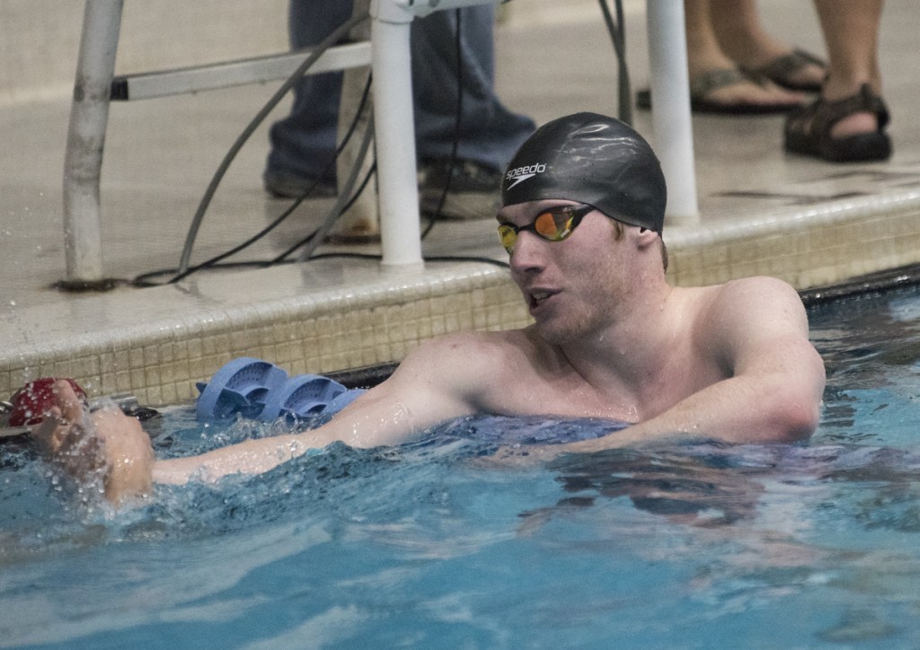 Brian Hess of Brunswick is congratulated after winning the 50-yard freestyle during the boys Class A swimming and diving championships Saturday in Orono.