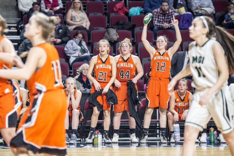 Winslow's Haley Ward (21), Weslee Littlefield (44) and Paige Trask (12)celebrate as the Raiders defeated Mount Desert Island School in a Class B North quarterfinal game Friday night at the Cross Insurance Center in Bangor.