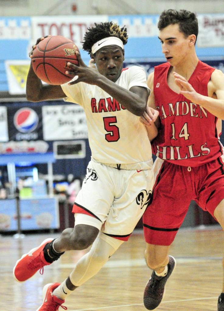 Cony sophomore guard Simon McCormick, left, drives past Camden Hills senior guard Jessie Frasier during a Class A North quarterfinal game Saturday at the Augusta Civic Center.