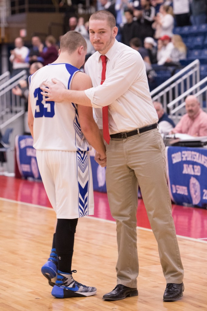 Valley's Mason Wyman gets a pat on the back by assistant coach Carrington Miller as Wyman leaves a Class D South semifinal game against Gould on Wednesday morning at the Augusta Civic Center.