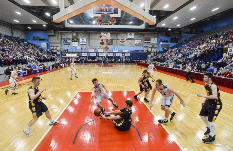 Hampden's Kory Winch, center, tries to stop Medomak's Nathan Emerson from making a pass from the floor during the Class A North title game Friday night in Augusta.