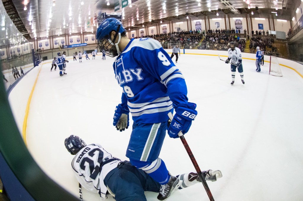 Colby's Joe Schuler stands over SUNY Geneseo's David Szmyd during the first period of an NCAA Division III quarterfinal game.