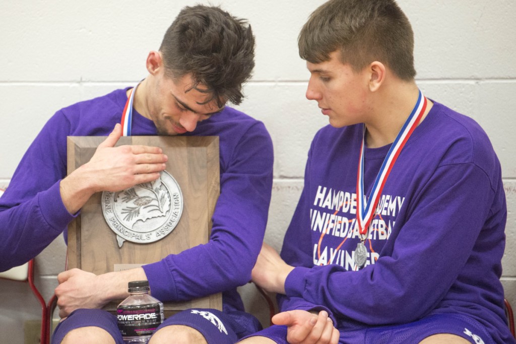 A Hampden Academy unified basketball player hugs the runners up plaque after the Broncos fell to Westbrook in the state final Thursday in Waterville.