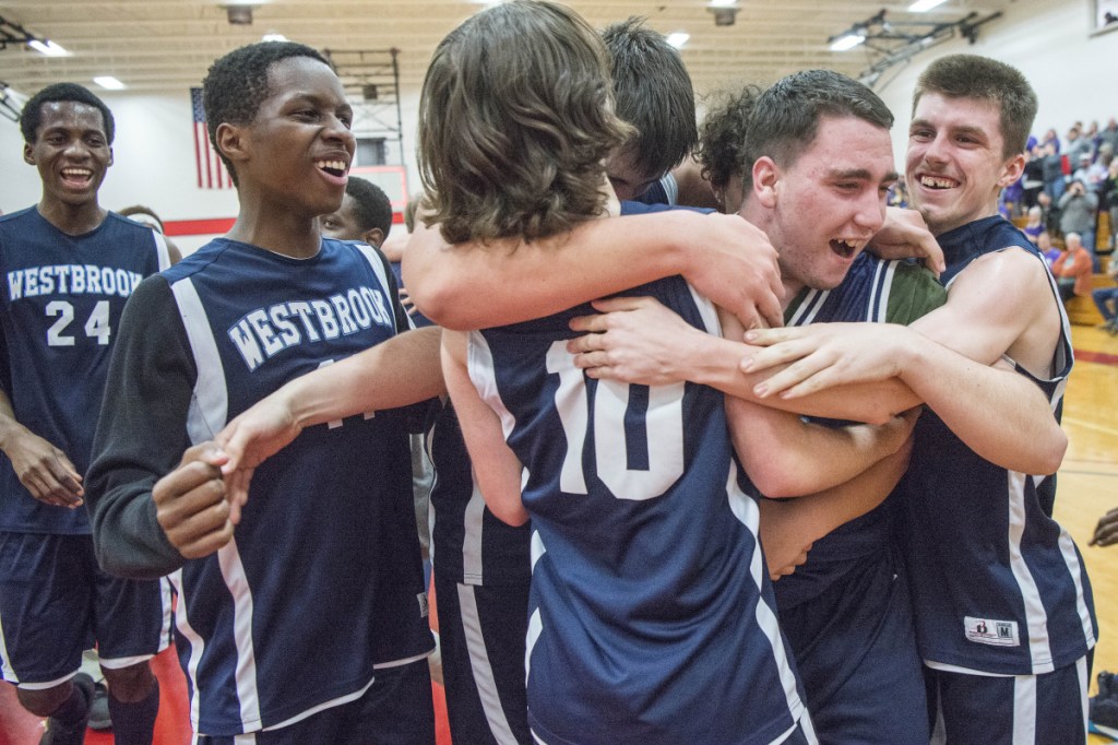 Members of the Westbrok High School unified basketball team celebrate after they beat Hampden Academy in the state final Thursday night at Thomas College in Waterville.