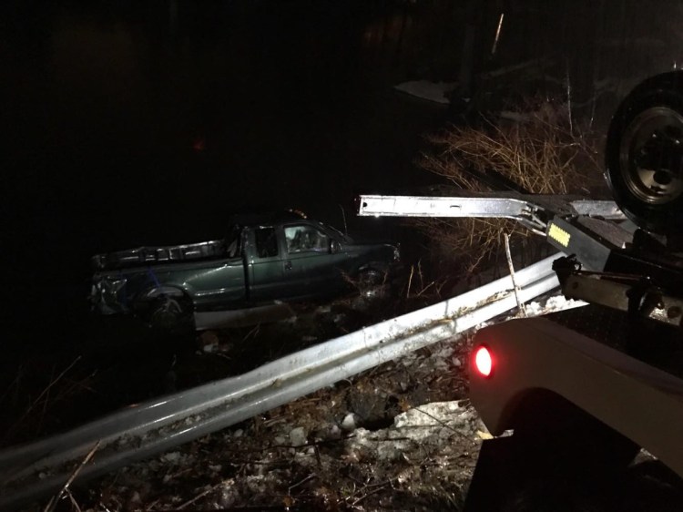 A Ford F-150 pickup truck sits in the Kennebec River early Friday. Police say the truck was unable to negotiate a corner on Alder Street and went over the guardrail.