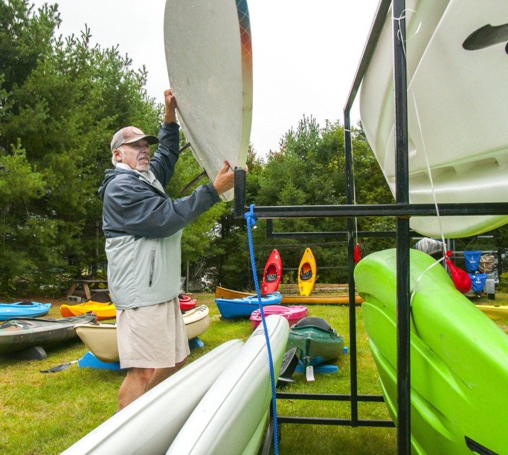 Ralph Ardito Jr. holds up one of his wares at his business, Belgrade Canoe and Kayak, on Route 27 in Belgrade in September 2017. The town was planning to sell the foreclosed property until Ardito went in and paid three years' worth of back property taxes.