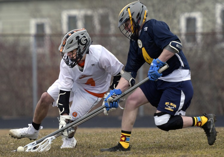 Gardiner's Nathan Phillis, left, grabs the ball from under Mt. Blue's Matt Hyde during a game Thursday in Gardiner.