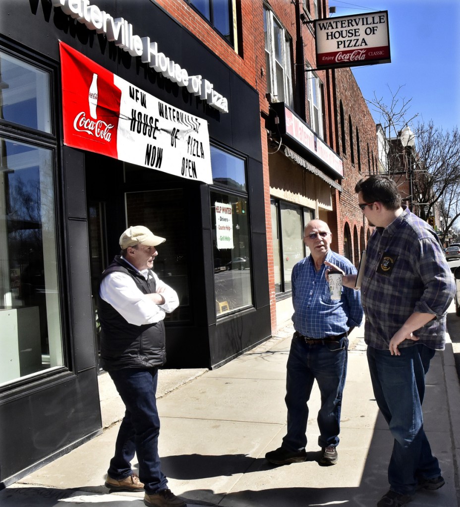 Waterville House of Pizza owner Stavros Kosmidis, center, speaks with Waterville Code Enforcement officer Dan Bradstreet, right, and Mark McCluskey outside his new restaurant beside the former location on Main Street in Waterville on Monday.