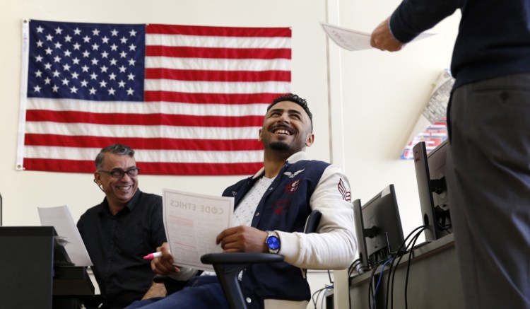 Ahmed Al Shuwaili, center, and Adul Karim share a lighthearted moment with instructor Sam Smithwick at Biddeford Adult Education. Thanks to the program, Al Shuwaili was accepted to Maine Maritime Academy.
