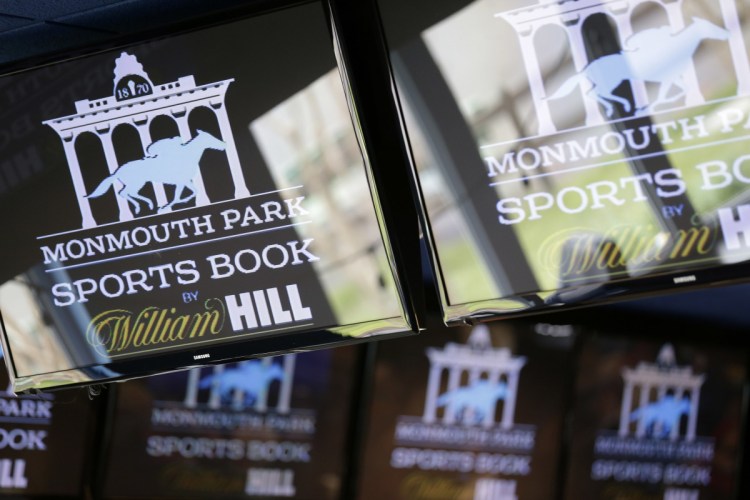 Signs for Monmouth Park are displayed in a bar at the racetrack in Oceanport, N.J., on Monday. The Supreme Court on Monday gave its go-ahead for states to allow gambling on sports across the nation, striking down a federal law that barred betting on football, basketball, baseball and other sports in most states.