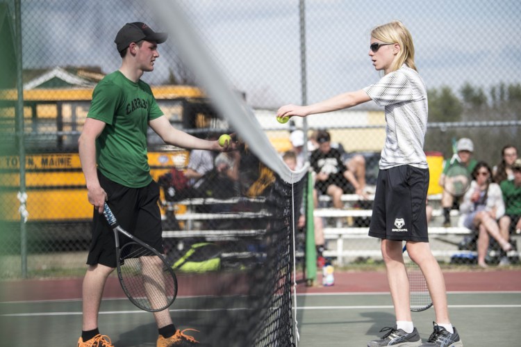 Carrabec High School's Scott Mason, left, hands two balls over to Hall-Dale High School's Eli Spahn, right, for the serve at Carrabec High School in North Anson on Wednesday.