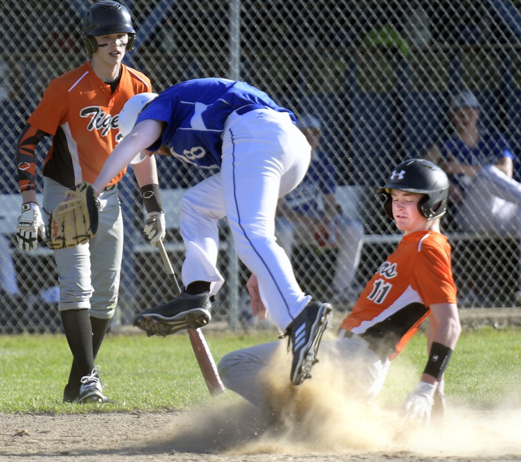 Erskine's Jack Allen leaps over Gardiner's Casey Bourque at home during a baseball game Monday in South China.