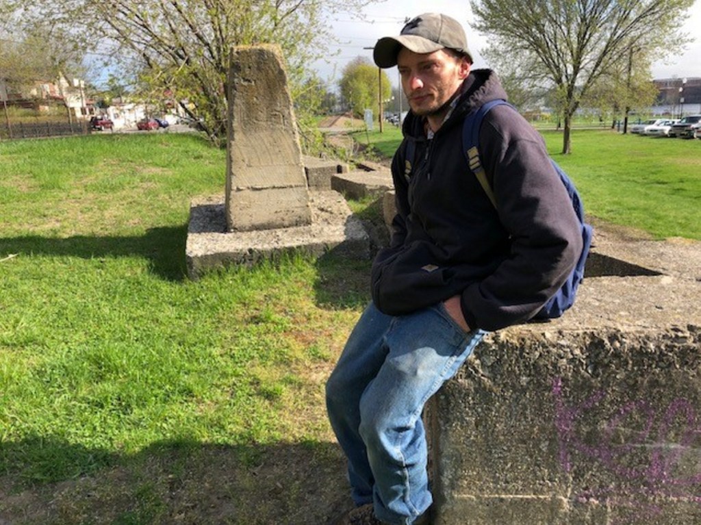 Clifford Perkins, 34 and homeless, sits on Wednesday on a concrete abutment overlooking Head of Falls off Front Street in Waterville.