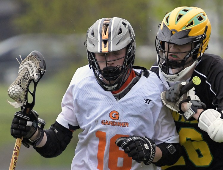 Gardiner's Kyle Johnson, left, is checked by Maranacook/Winthrop's Owen Austin on Tuesday in Gardiner.