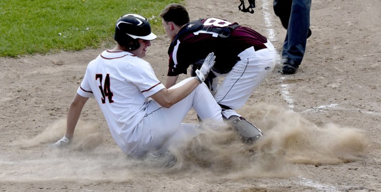 Skowhegan's Kiel Lachapelle (34) slides into home plate as Nokomis catcher Joahua Grozik attempts the tag Monday in Skowhegan.