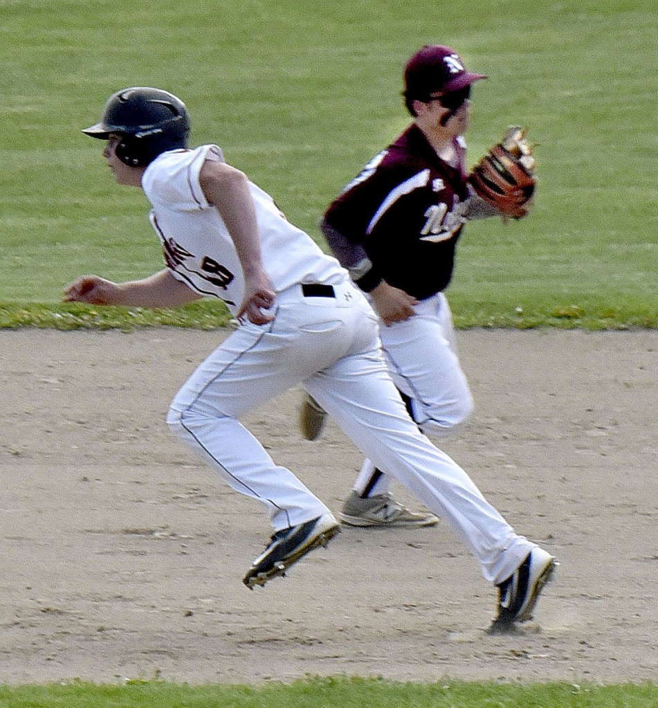 Skowhegan's Ryan Savage, left, runs past  Nokomis' Alex Higgins in a run-down play during game Monday in Skowhegan.