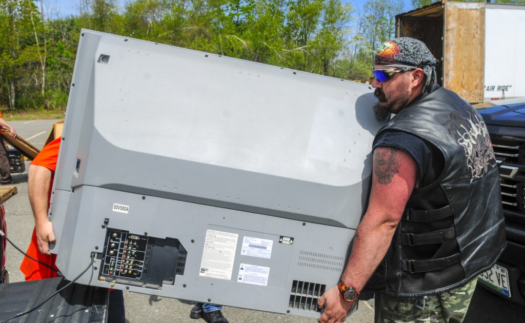 An employee of e-waste Recycling Solutions, left, and volunteer Tony Fratus carry away an old television during an e-waste recycling event on Saturday in the Augusta Civic Center parking lot. People made donations to drop off items and the event was a fundraiser for Bridging The Gap, which runs the Augusta Warming Center, Addie's Attic and Basic Essentials Pantry. The group wants to move its social services to the Emmanual Lutheran Episcopal Church on Eastern Avenue in Augusta.