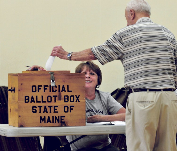 Last year's SAD 13 budget weathered four votes before it passed. Stanley Redmond casts his ballot as clerk Liz Brochu looks on during voting at the Quimby School in Bingham on July 25, 2017.