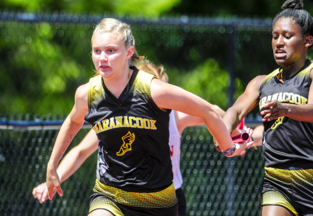 Staff photo by Joe Phelan 
 Maranacook's Grace Despres, left, takes the baton from Kiana Gordon in the 4x100 meter relay during the Class C track and field meet Saturday in Waterboro.