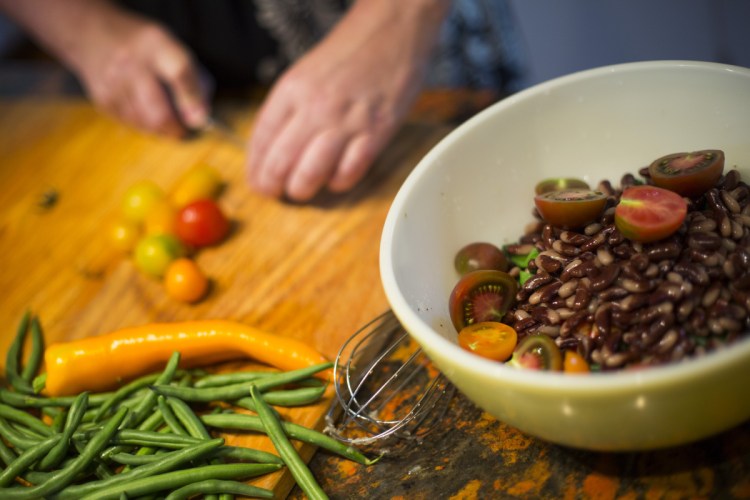 Christine Burns Rudalevige halves cherry tomatoes to add to her bean salad.