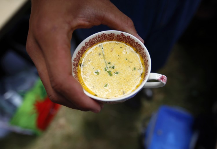 Dawud Bloomstein, 15, of Freedom serves chowder to guests at "re:past" on Malaga Island.