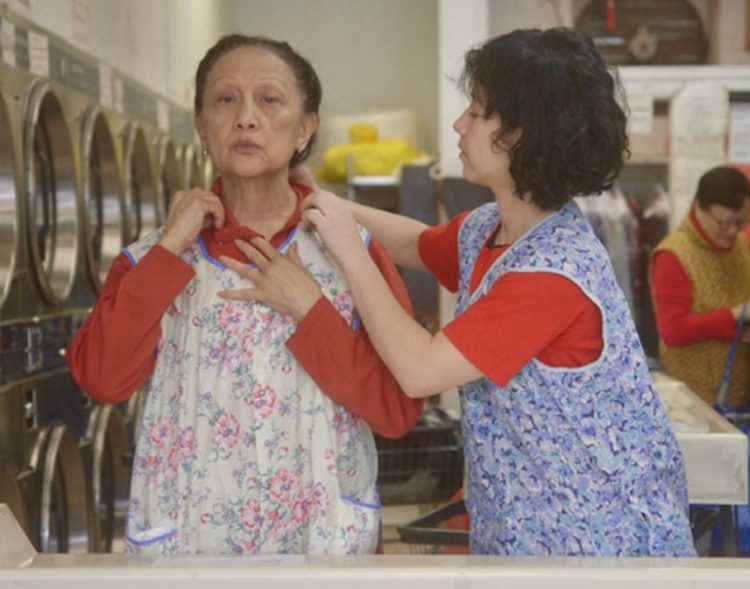 Two of the proprietors of a New York City laundromat try on some recently washed clothes of their own in the documentary "The Washing Society."