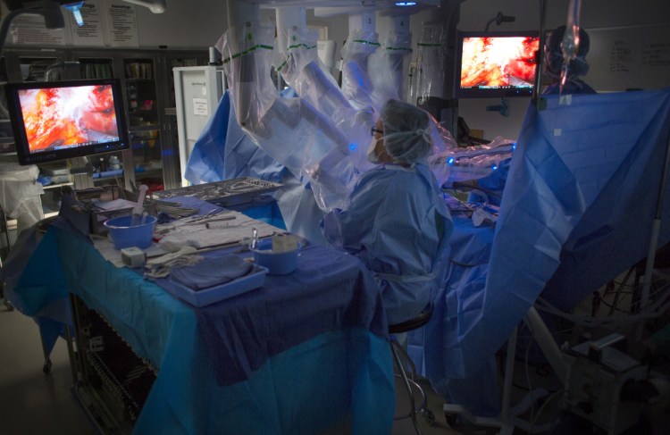 Susan Nelson, a certified surgical technician, helps to perform robot-assisted surgery at Maine Medical Center. The hospital has three robots and went from 462 robot-assisted surgeries in 2012 to 1,040 in 2017.