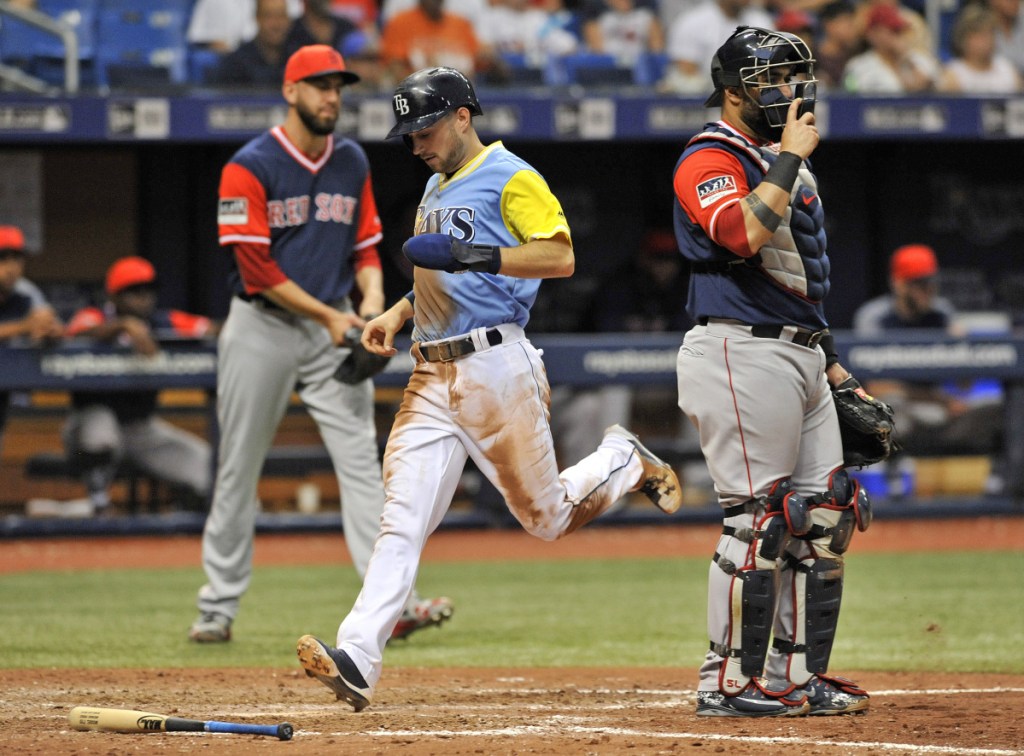 Red Sox pitcher Matt Barnes, left, backs up catcher Sandy Leon, right, as Tampa Bay's Brandon Lowe, center, scores on Michael Perez's two-run double during the seventh inning Boston's 9-1 loss to Tampa Bay on Sunday in St. Petersburg, Fla.