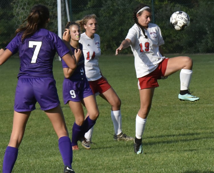 Staff photo by David Leaming 
 Messalonskee's Lily Wilkie knees the ball as Waterville's Sophia Poole, left, and Jess Bazakas pressure her during a game Tuesday in Waterville.