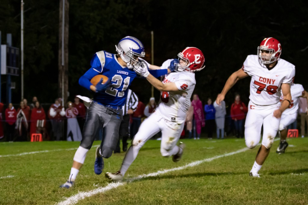 Lawrence's Zack Nickerson, left, runs the ball upfield while trying to avoid being tackled by Cony's Dakota Andow on Friday in Fairfield.