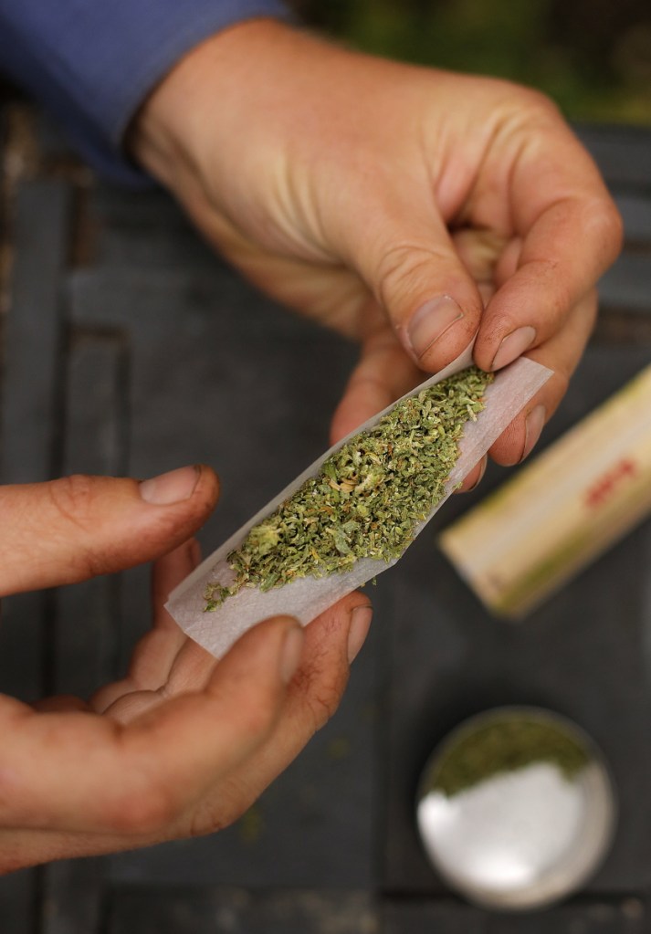 A smoker rolls a marijuana cigarette in 2013 in Portland. The Fairfield Town Council on Wednesday plans to consider ordinance changes to allow retail marijuana businesses in certain town zones.