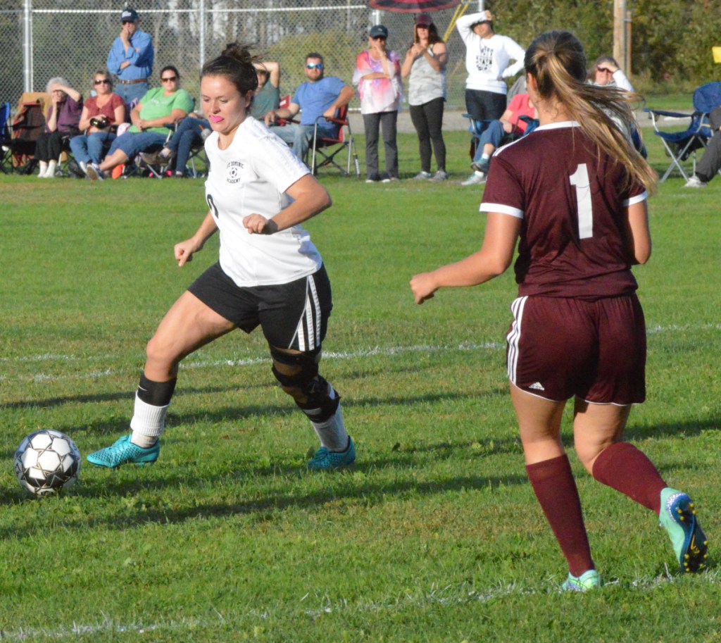 St. Dominic's Abby Castonguay, left, turns to make a shot attempt in front of Richmond defender Marybeth Sloat (1) in Thursday's game in Richmond.