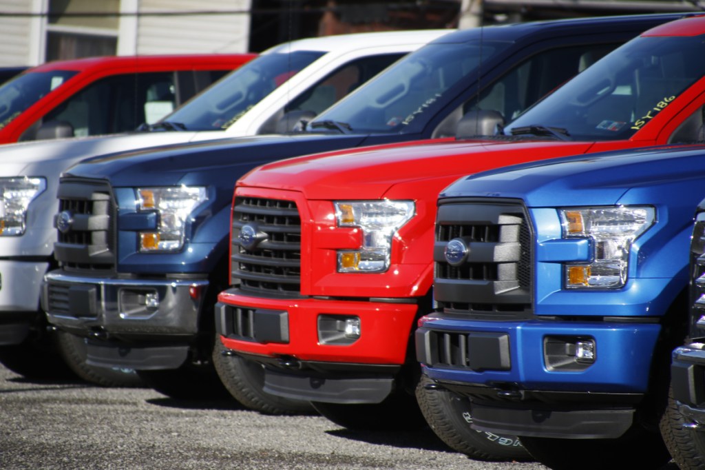 FILE- In this Nov. 19, 2015, file photo a row of 2015 Ford F-150 pickup trucks are parked on the sales lot at Butler County Ford in Butler, Pa. Under pressure from U.S. safety regulators, Ford is recalling about 2 million F-150 pickups in North America because the seat belts can cause fires. The recall covers certain trucks from the 2015 through 2018 model years. Associated Press/Keith Srakocic