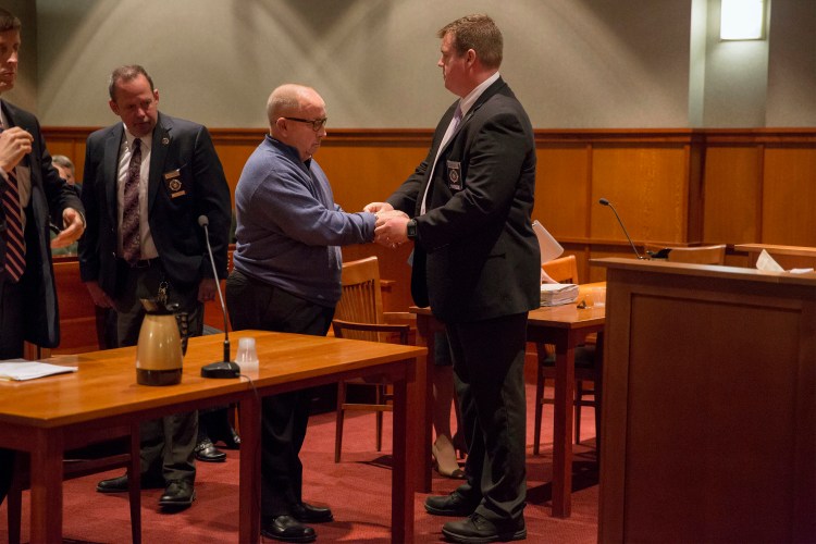 James Talbot, former priest and Cheverus High School teacher, is handcuffed by a bailiff on Sept. 24 at the Cumberland County Courthouse after pleading guilty to sexually assaulting a minor and being sentenced to serve three years in prison.