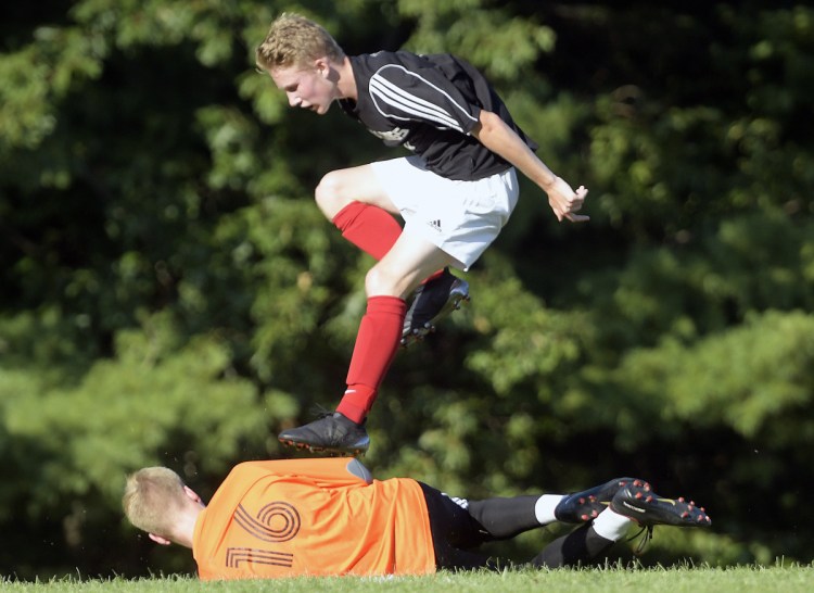 Hall-Dale's Ian Stebbins leaps over Monmouth goalie Connor Davies  during a Mountain Valley Conference game Wednesday in  Farmingdale.