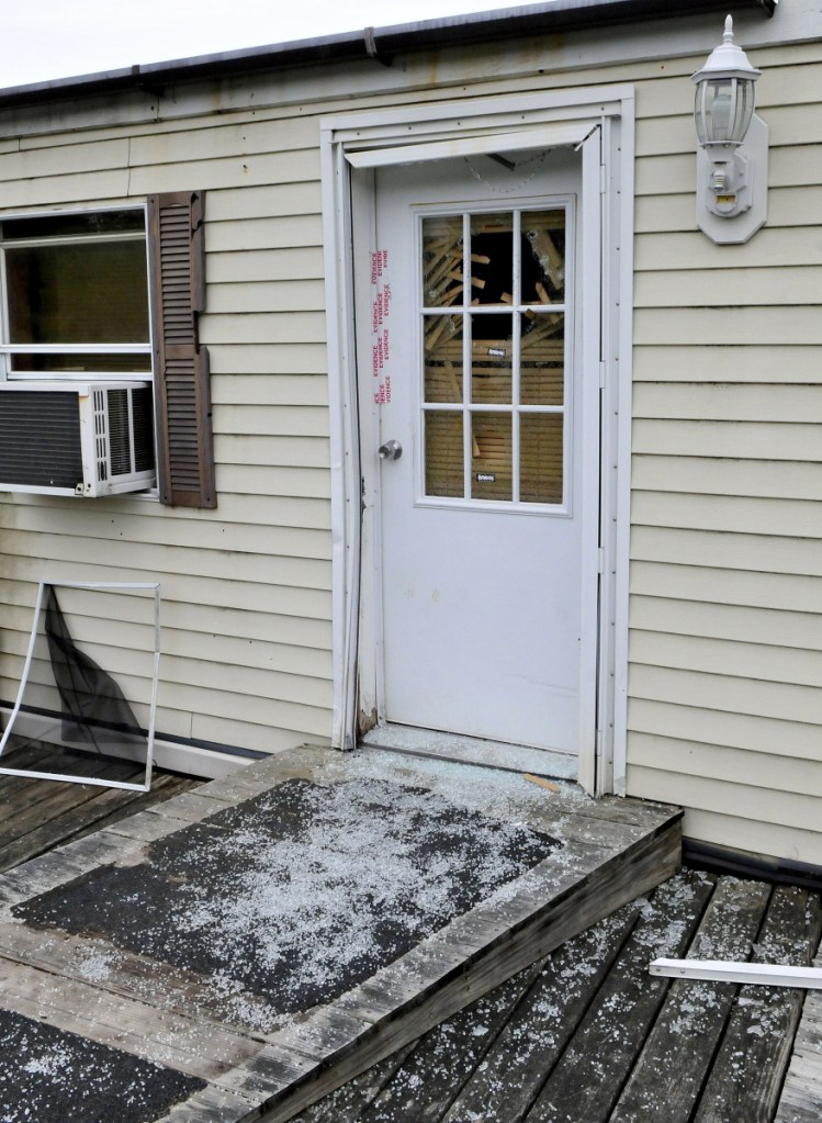 Glass from a shattered window in a door that is sealed with police evidence tape is seen at the front entrance to a mobile home at 1003 Oakland Road in Belgrade on May 22, 2017. Homeowner Roger Bubar died in a police officer-related shooting on May 19, 2017, and his son, Scott Bubar, was seriously wounded.